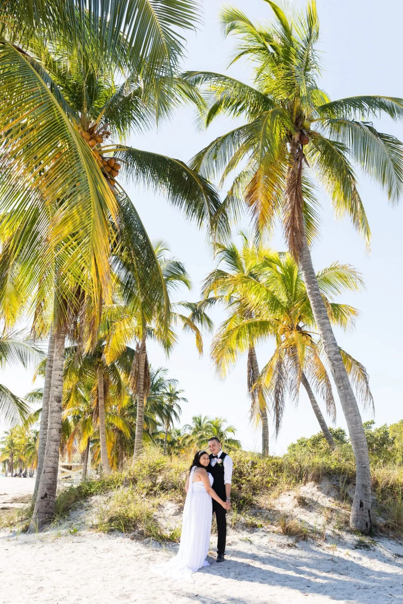 Wedding portraits on wide sandy beach at Crandon Park