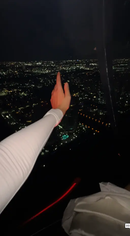 Hand pointing out over Miami city lights from a helicopter