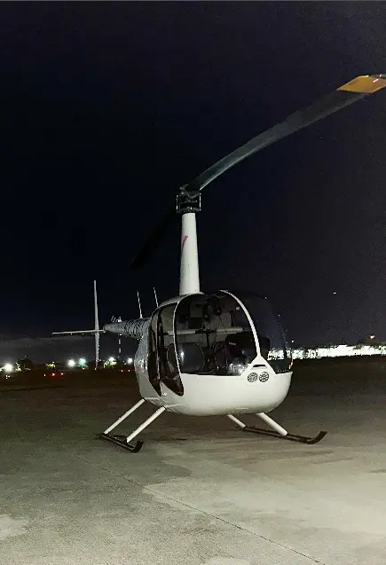 White Robinson helicopter on the Miami tarmac at night