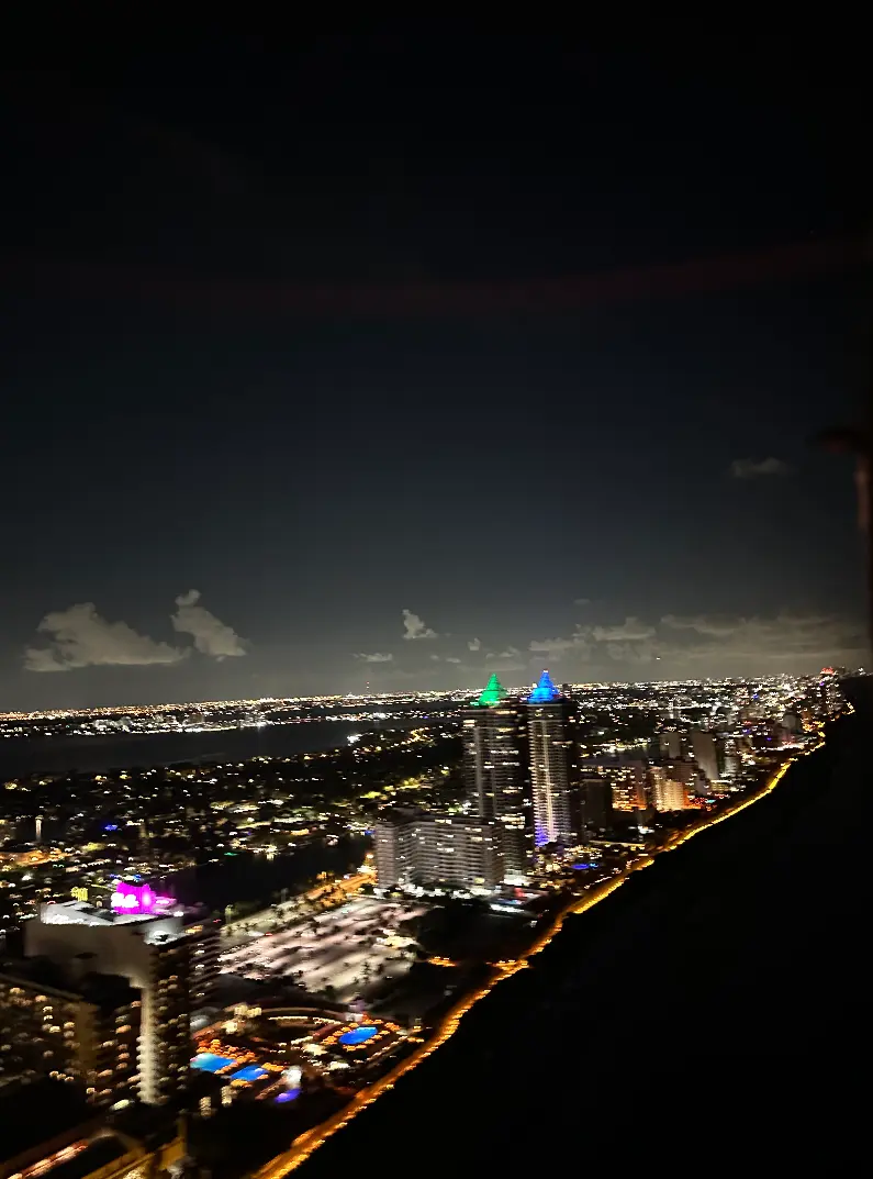 Long perspective of Miami coastline at night from a helicopter